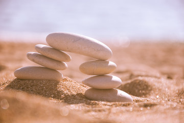 Balanced stone pyramid on sand on beach. Zen rock, concept of balance and harmony