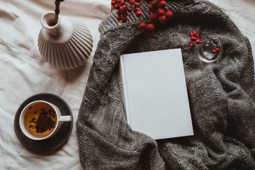 Christmas mock up with book cover and tee. Greetings card new year book mockup with red rowan berries over gray wool plaid. White book cover winter cozy mock-up.Warm festive rowan tree backdrop.