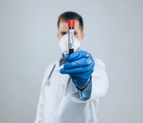 Doctor wearing respiratory mask and holding the Coronavirus blood sample