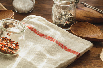 Striped linen napkin on wooden table with kitchen utensils close up
