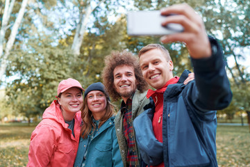 Holidays with friends. Group of young people taking selfie together in the park.