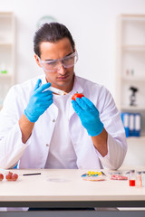 Young male nutrition expert testing food products in lab