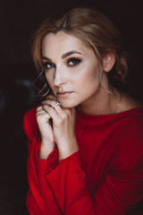 Portrait of a beautiful romantic woman lady in a red dress in a room in the loft style. Soft selective focus. Beauty, fashion.