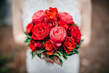 Brautstrauss aus roten Rosen in der Hand der Braut am Tag der Hochzeit