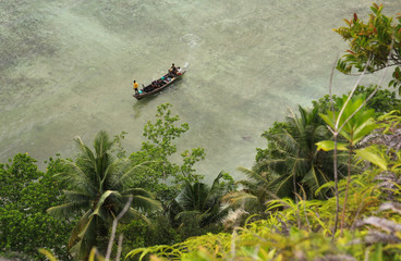 Boat approaching shore in tropical sea destination Pasumpahan island