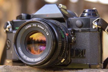 Fototapeta na wymiar Sunset in the forest reflected in analog film camera lens