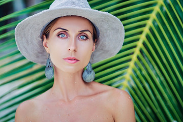 Vacation and natural beauty. Close up outdoor portrait of pretty tanned young woman in hat.