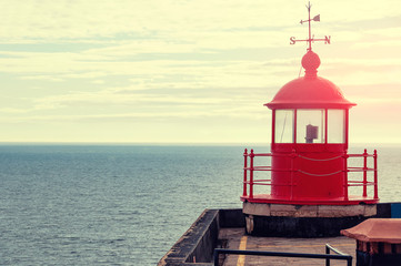 Tow-in surfing in Nazar&eacute;, Portugal. Red lighthouse.