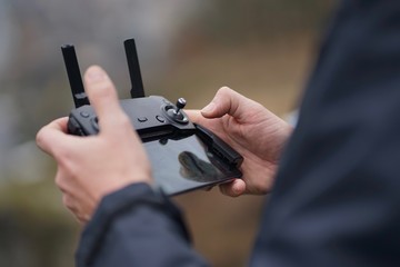 Close up of male hands holding a remote control to operate, fly a drone   