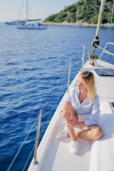 Luxury travel on the yacht. Young happy woman on boat deck sailing the sea. Yachting in Greece.