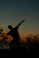 Fototapeta na wymiar Silhouette on the Adriatic sea of a boy raising his arms