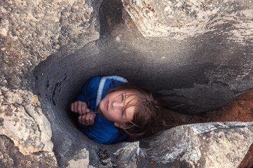 Girl among the rocks. Hopelessness and Get stuck.  girl fell into the hole