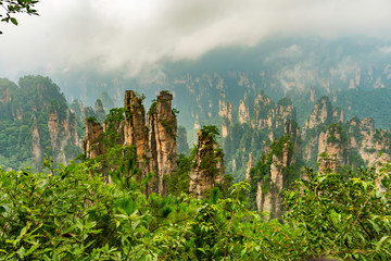 Panorama of mountain range (Yubi Feng Peaks) with low clouds and fog  in Yellow Stone Stronghold (Huangshi Zhai) in Yuanjiajie Scenic Area , Zhangjiajie National Park, China