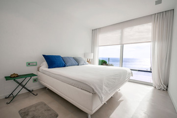 Modern bedroom with sea view with smart home control panels.