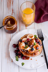 Delicious and lush pancakes with fresh fruits and berries, poured with salted caramel.