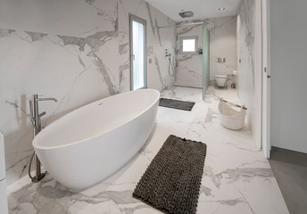 Naklejka na ściany i meble Luxury white marble bathroom with with a luxury freestanding bathtub and washbasins. Concept for lifestyle and luxury living.