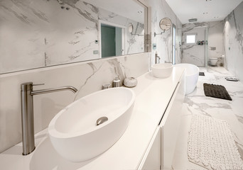 Luxury white marble bathroom with with a luxury freestanding bathtub and washbasins. Concept for lifestyle and luxury living.