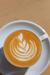 Breakfast in the cafe. Beautiful blue mug with cappuccino or latte coffee on a wooden table. View from above. 