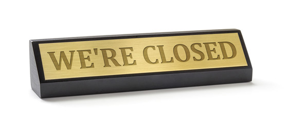 A name plate on a white background with the engraving We are closed