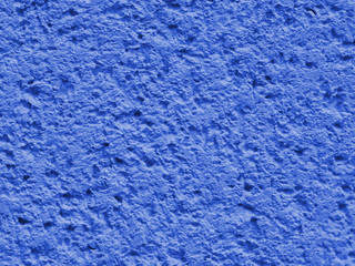 Fototapeta na wymiar Blue background facade plaster . Monolithic plaster decorative backdrop. Single layer scraped cement plaster wallpaper. Exterior building structure backdrop. Silica sand cement wall plaster