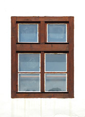 Old brown closed wooden window home with glass on a background with a white facade. Plastic window frame house with natural wood imitation. Design element of architecture