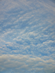 Summer background with white flying clouds on blue sky. Romantic natural heaven backdrop.