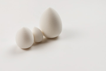 Small, medium and large  white beauty blender isolated.