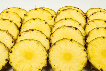 Pineapple juicy yellow slices background. Top view.