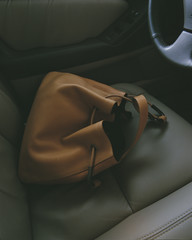 Brown handbag in the front seat of a car