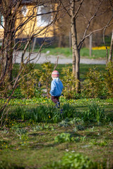 child playing in a green garden