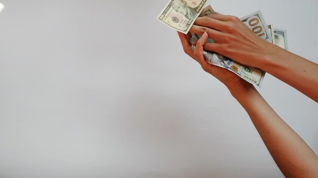 Close-up view of loose money pouring down and hands trying to catch this money on a white isolated background. Money is flying in the air. Euro notes and dollars fly down. Financial crisis