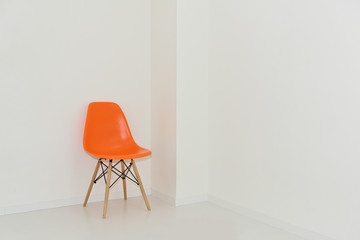 白い部屋とオレンジ色の椅子