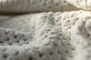 Fine textured and voluminous fabric in white and gray. Embossed textile pattern, pleasant to the touch and delicate, velvety and textured background for design and decoration.