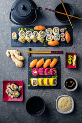 apanese sushi food. Maki ands rolls with tuna, salmon, shrimp, crab and avocado. Top view of assorted sushi. Rainbow sushi roll, uramaki, hosomaki and nigiri