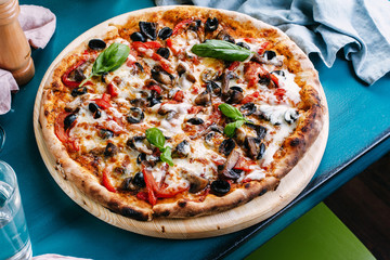 Neapolitan pizza with olives, paprika and mushrooms