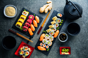 apanese sushi food. Maki ands rolls with tuna, salmon, shrimp, crab and avocado. Top view of assorted sushi. Rainbow sushi roll, uramaki, hosomaki and nigiri