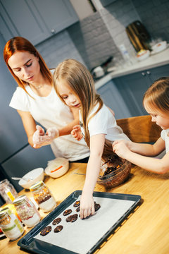 Portrait Of Happy Mother And Two Daughters Cooking