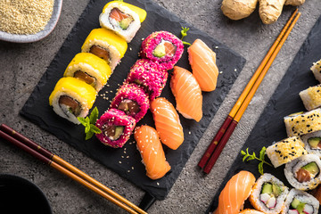 apanese sushi food. Maki ands rolls with tuna, salmon, shrimp, crab and avocado. Top view of assorted sushi. Rainbow sushi roll, uramaki, hosomaki and nigiri