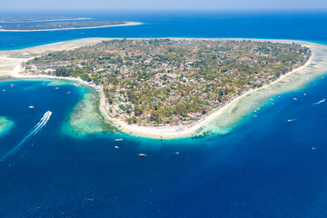 Aerial view of a beautiful tropical island surrounded by fringing coral reef and a deep,blue ocean