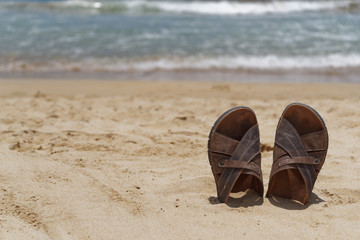 Sandal shoes in a sand on the beach against sea