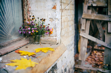 Fototapeta na wymiar Still life with beautiful flower bouquet of autumn flowers near the old window