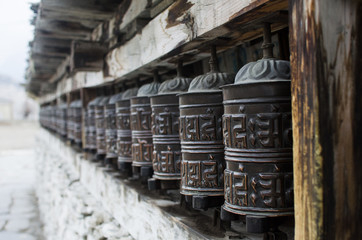 Fototapeta na wymiar Detalle de ruedas de oración metálicas con mantras en el Himalaya
