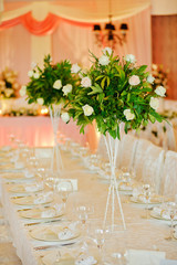 Flower table decorations for holidays and wedding dinner. Table set for holiday wedding reception in restaurant.