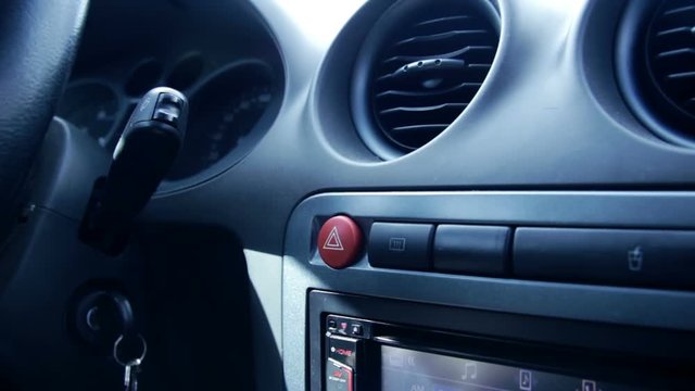 Female hand pressing emergency button in auto, stop by roadside, car accident