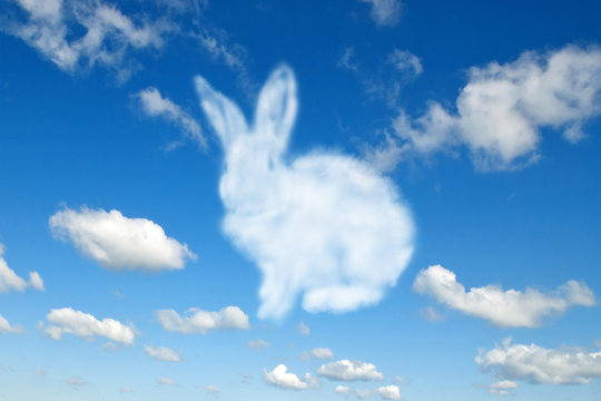 Shape of fluffy cloud Easter bunny on a cloudy sky blue background.