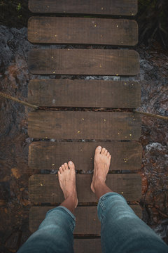 Pies sobre un puente de madera colgante en un bosque