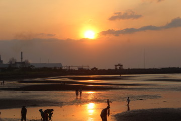 atmosphere beach sunset time many silhouettes of people playing on the shore