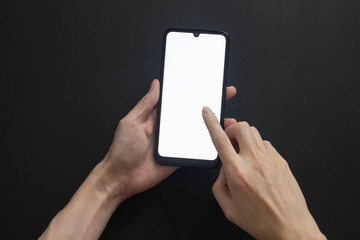 Pressing the index finger on the smartphone screen on a black isolated background.