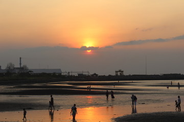 atmosphere beach sunset time many silhouettes of people playing on the shore