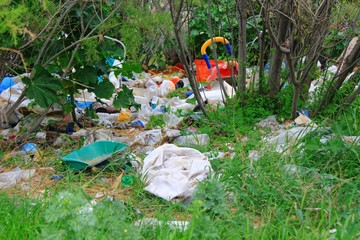 Pile of garbage in forest, trash left by illegal immigrants at coastal site of Attica in Greece